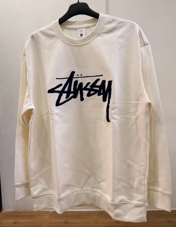 An off-white, crewneck sweatshirt